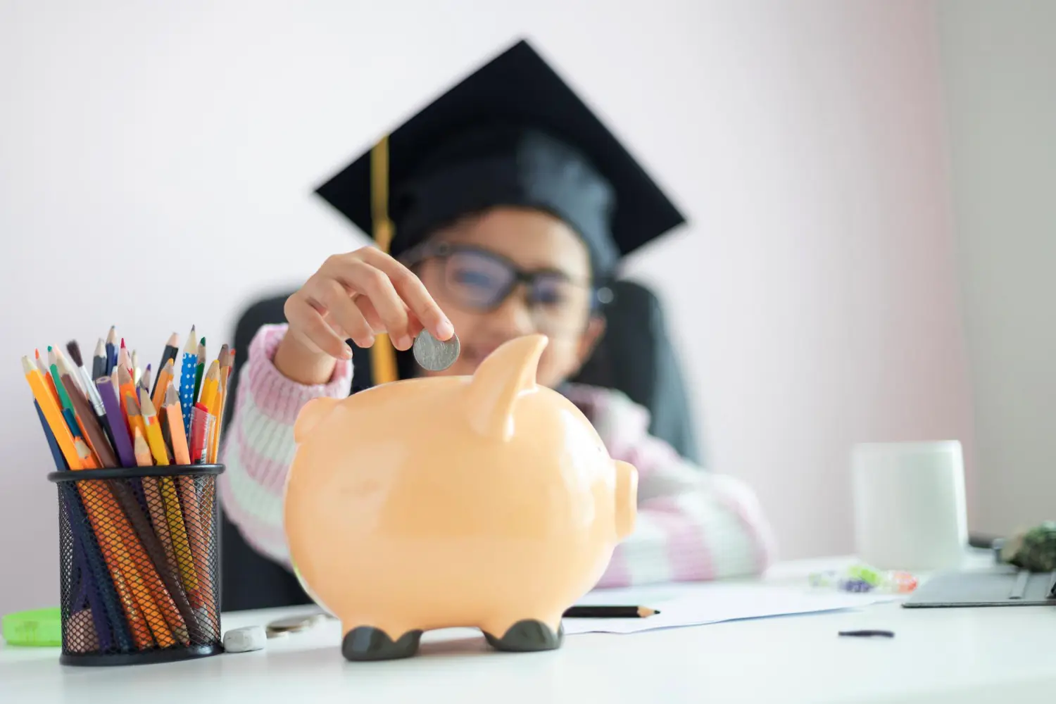 Educação financeira infantil Criança colocando moeda em cofrinho enquanto aprende conceitos de educação financeira infantil