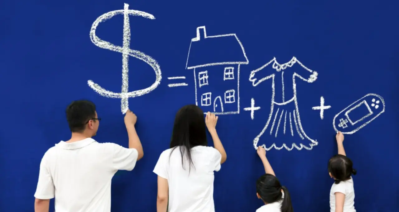 Educação financeira: o que é, para que serve, como desenvolver e boas práticas Família desenhando metas financeiras como casa, roupas e eletrônicos em quadro representando educação financeira.