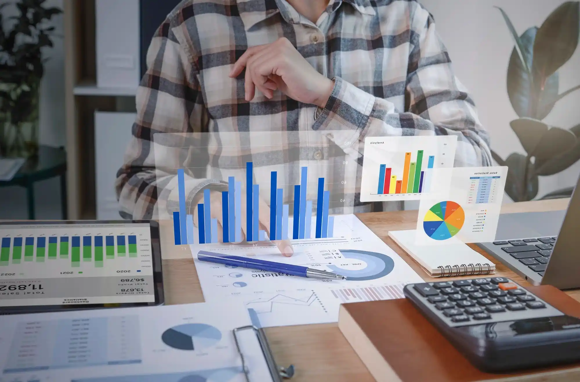 Profissional realizando modelagem financeira, com gráficos e tabelas em uma mesa