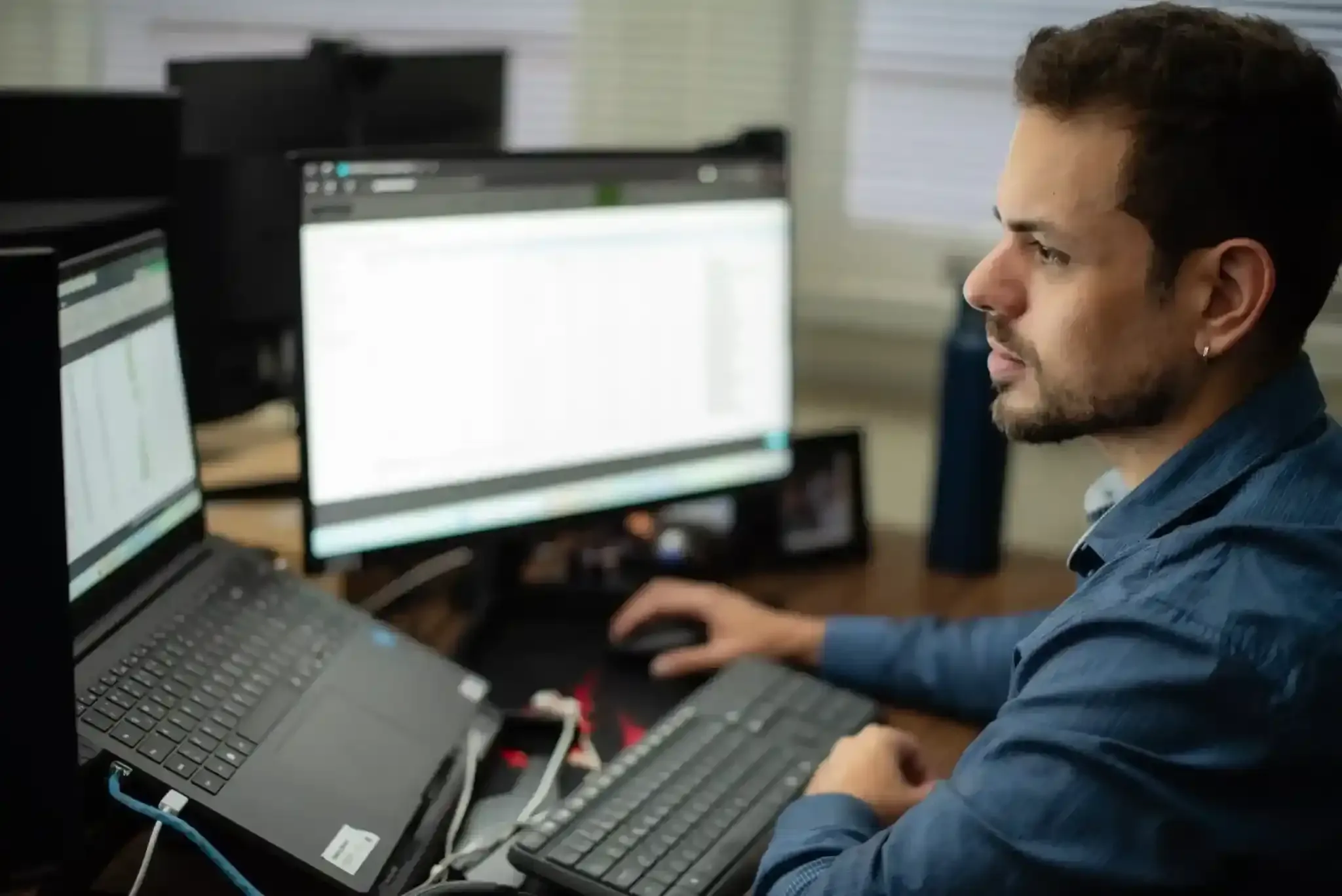 Profissional analisando dados em dois monitores como parte do planejamento de segurança financeira pessoal.
