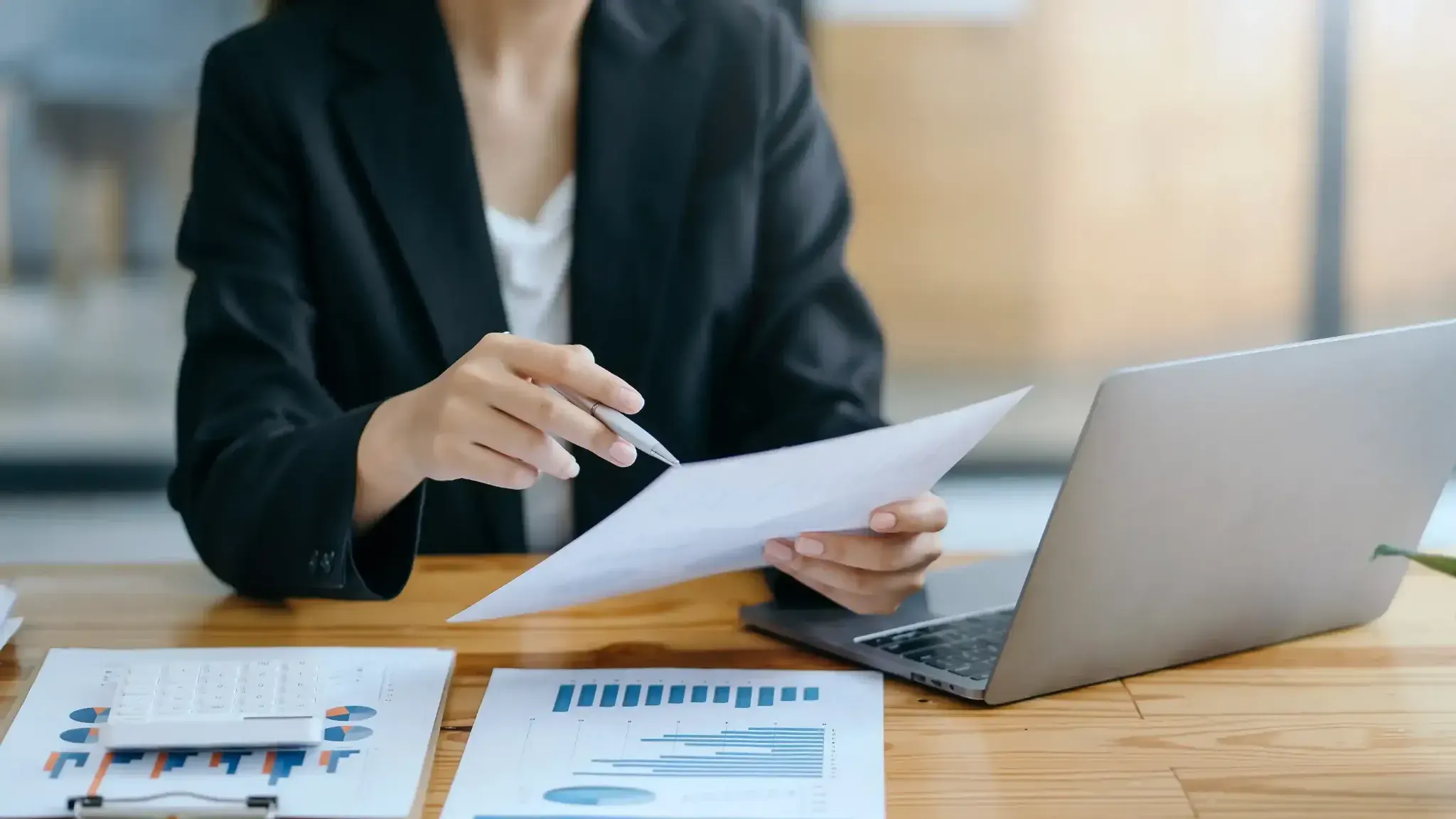 Orçamento empresarial: o que é, quando fazer, tipos e como elaborar Profissional analisando dados de orçamento empresarial com relatórios financeiros e notebook