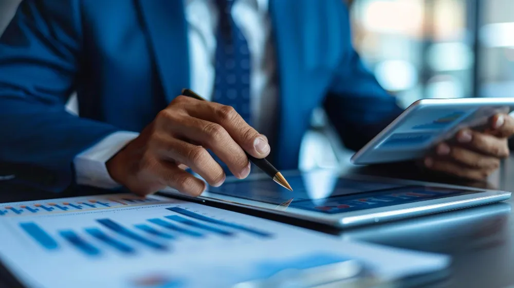 Profissional analisando relatórios financeiros em tablet para avaliar desempenho da empresa