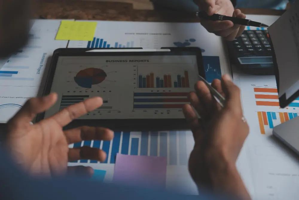 Ferramentas de FP&A Equipe analisando relatórios em tablet com gráficos e planilhas como ferramentas de FPA
