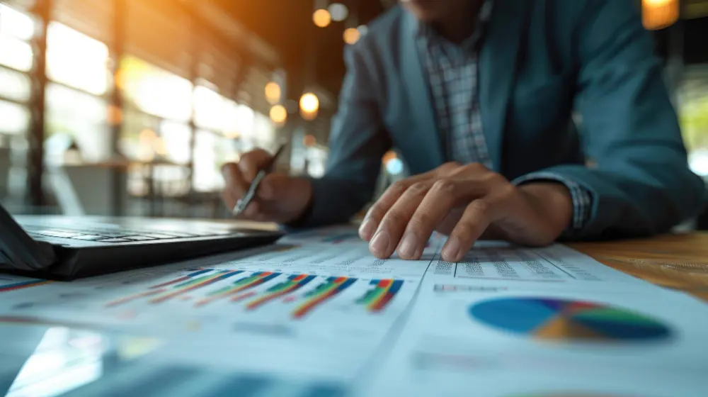 FP&A: o que é e como saber se sua empresa precisa do serviço de Planejamento e Análise Financeira | Imagem por Magnific/markfalconcode Executivo analisando gráficos e planilhas impressas em reunião de FPA planejamento e analise financeira