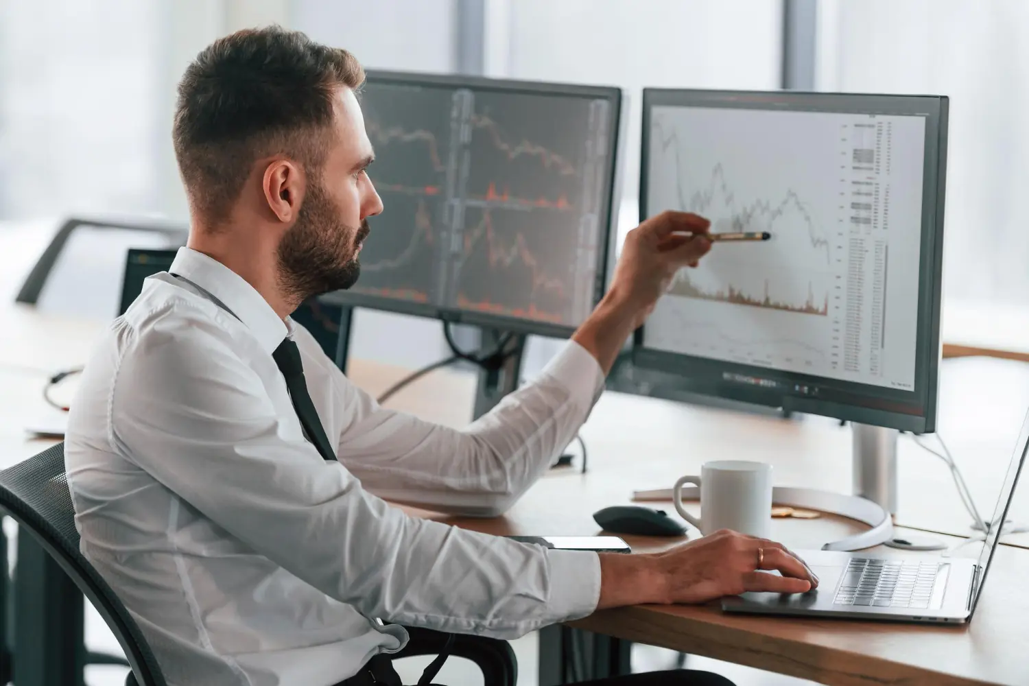 O que é EBITDA? Como calcular e qual a importância do indicador na gestão do seu negócio Analista financeiro observando gráficos de desempenho para entender o que é EBITDA